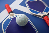 Fototapeta Dziecięca - Detail of blue and red pickleball paddles on playing court