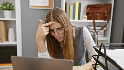 Wall Mural - Unhappy young blonde business worker pointing at ugly acne pimple on forehead, battling skin problem at the office