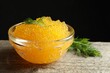 Fresh pike caviar in bowl on wooden table, closeup