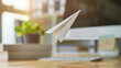 A paper airplane with a thank you message flying through the office, symbolizing playful appreciation