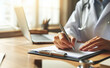 © Carlostock - Close-up of an independent medical office where the doctor's hands are seen writing notes on their medical prescription documents
