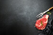 Raw meat steak with spices on black background. Beef steak ribeye. Top view with copy space.