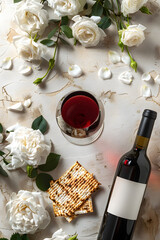 Wall Mural - Matzah, red kosher wine and white rose flower. Passover celebration. Jewish Pesach holiday with traditional ritual bread. Background for greeting card, banner with copy space. Top view, flat lay