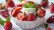 A bowl of strawberries with whipped cream on top