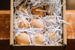 © Adrian Cotiga/Stocksy - Eggs nestled in shredded paper in a box