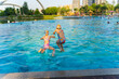 © Bo Bo/Stocksy - two Asian kids jumpping in the swimming pool