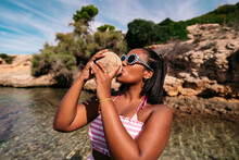 Black Woman Drinking From Coconut In Summer