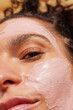 © Anna Tabakova/Stocksy - Woman with pink clay face mask