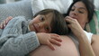 Son leaning on mother's belly during third trimester pregnancy. Tender caring relationship awaiting for baby brother to arrive, close-up faces and hand