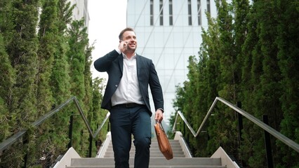 Wall Mural - Caucasian businessman walking up stair and calling manager by using smart phone. Top view of manager talking marketing team and planning financial strategy by telephone while going up stair. Urbane.