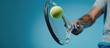 Tennis player is holding racquet and hitting ball on blue background