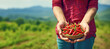 A close-up of a female farmer with a basket of fiery red chili peppers, illustrating the nature of the flavorful ingredient she's cultivated.