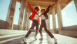 Two young women express joy and freedom as they dancing under sunlight on stone dance ground with columns. Their exuberant movements convey sense of happiness and vitality.