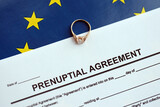 Fototapeta  - Prenuptial agreement and wedding ring on table. Premarital paperwork process in europe close up