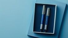 Two Gift Metal Pens In A Chic, Opened Case Made Of Paper Or Soft Plastic. Present Box Packaging. Silver And Blue Colored Pencils.