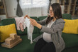 © Miljan Živković - Adult pregnant women have a video call on tablet and share baby wear