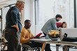 © qunica.com - An inclusive modern office environment with a diverse team collaborating. A person in a wheelchair actively engages with colleagues.