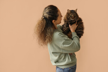 Wall Mural - Mature woman with cute cat on brown background