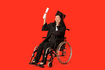 Wall Mural - Beautiful female graduate student in wheelchair with graduation cap and diploma talking by mobile phone on red background