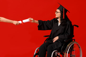 Wall Mural - Beautiful female graduate student in wheelchair with graduation cap and hand with diploma on red background