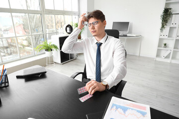 Poster - Young businessman with pills and glass of water suffering from headache in office