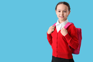 Canvas Print - Happy little schoolgirl with backpack on blue background