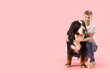 © Pixel-Shot - Little boy with Bernese mountain dog on pink background