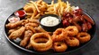 © Matcha_09 - Street food plate with mozzarella sticks, chicken wings, onion rings, french fries and dip