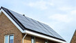 Newly built houses with black solar panels on the roof against a sunny sky Close up of new building with black solar panels. Zonnepanelen, Zonne energie, Translation: Solar panel, Sun Energy