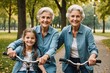 Grandmother and granddaughter in park on bicycle looking at camera smiling
