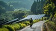A cyclist wearing gear made from recycled materials races down a winding road lined with solar panels with a lush forest in the background. On their bike is a bottle filled with biofuel .