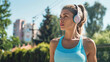 ©  Mohammad Xte - Caucasian sports woman listening to music on headphones outdoors -
