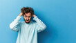 ©  Mohammad Xte - Man feeling anxious and tormented on pastel blue background