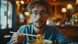 Young man eating noodles with chopsticks