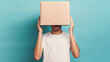 Young man in a white T-shirt with a cardboard box on his head on pastel blue background