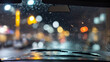 a car's windshield with a view of a rainy city street at night