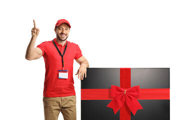 Canvas Print - Salesman pointing up and leaning on a flat lcd tv screen tied with a red ribbon