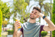 Sport man holding an orange juice at outdoors
