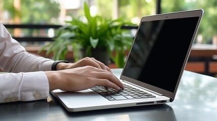 Person working on a laptop with a blank screen at his desk