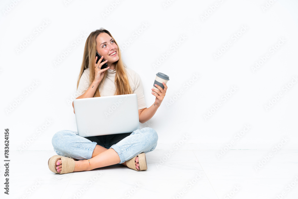 Young woman with laptop sitting on the floor isolated on white ...