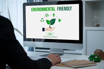 Businessman working in office developing plan or project on eco-friendly alternative energy with solar cell technology display on computer screen for greener environment as apart of CSR effort. Gyre