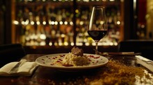 A Plate Of Risotto With Truffle And A Glass Of Wine On The Side