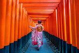 Fototapeta Miasta - Asian women in traditional japanese kimonos at Fushimi Inari Shrine in Kyoto, Japan.