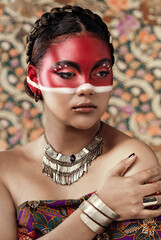 Poster - Culture, paint and girl in traditional, clothes or attire, pride and serious with respect for religion. Pattern, background and art on face, indigenous and person with makeup, red and color for tribe