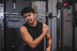 © Mdv Edwards - A fit young asian man experiences shoulder pain due rotator cuff tear, sprain or injury during a workout session at the gym.