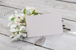 Apple blossom branches and card with copy space on a wooden background