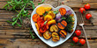 Vibrant Heart-Shaped Plate with Colorful Roasted Vegetables on Wooden Background
