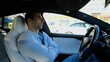 © ExpressVectors - Male businessperson experience to ride an autonomous self driving electric car at urban road. Confident businessman resting during riding on electrical auto with autopilot at city. Slow motion
