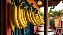  Bunches Of Ripe Bananas Hanging From A Colorful Wall