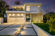© Wirestock - modern house exterior lighting on concrete driveway and lawning at night